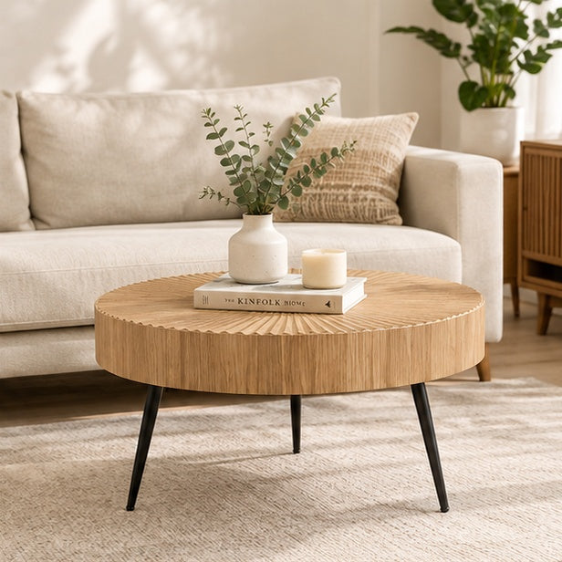 Table basse ronde sculptée effet bois dans un salon
